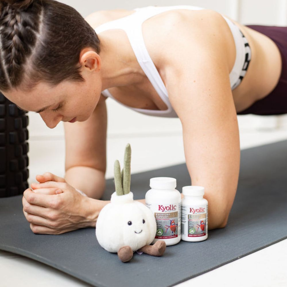 Kyolic Lifestyle Photo of A Fit Woman Doing a Plank Next to Kyolic Every Day Support Extra Strength Product